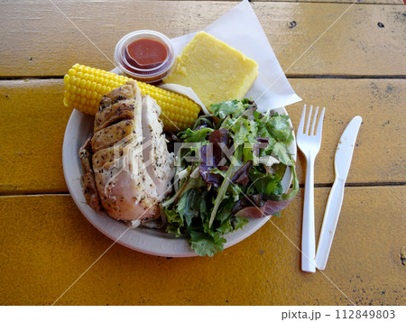 Herb chicken plate with nalo greens salad, corn on the cob, and corn beard Herb chicken plate with nalo greens salad, corn on the cob, and corn beard 112849803