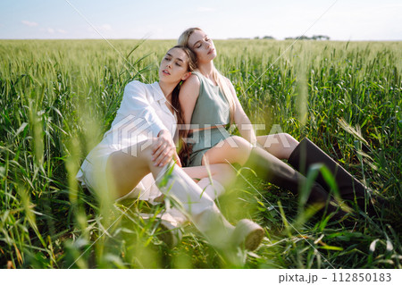 Two Beautiful woman in the green field. Nature, vacation, relax and lifestyle. Summer landscape. 112850183