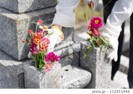 墓参り お墓に花を供えるシニア女性 墓参り お墓に花を供えるシニア女性 112851448