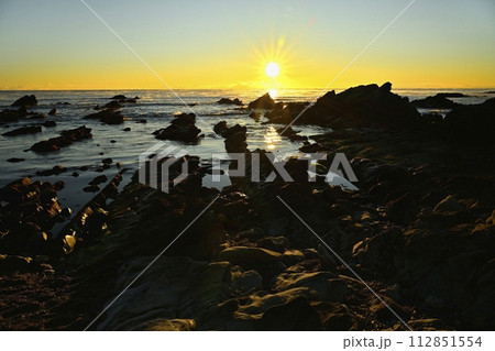 平磯海岸の白亜紀層岩礁に太平洋の霧立つ海面からの日の出 112851554