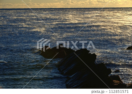 平磯海岸の白亜紀層岩礁に朝日差す太平洋の霧立つ海面 平磯海岸の白亜紀層岩礁に朝日差す太平洋の霧立つ海面 112851571