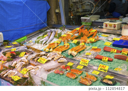 Tokyo, Japan - January 4,2020 : Merchants sell seafood at Tsukiji Fish Market in Tokyo, Japan on January 4,2020. Tokyo, Japan - January 4,2020 : Merchants sell seafood at Tsukiji Fish Market in Tokyo, Japan on January 4,2020. 112854817