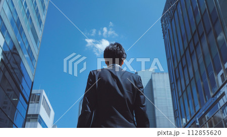 ビル街を見上げるビジネスマン 112855620