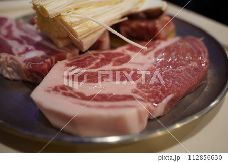 Thick and fresh raw meat and mushrooms are served. 112856630