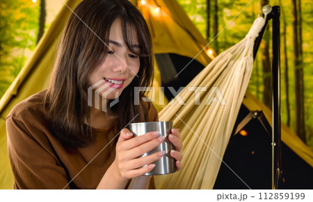キャンプでコーヒーを飲む若い女性 キャンプでコーヒーを飲む若い女性 112859199