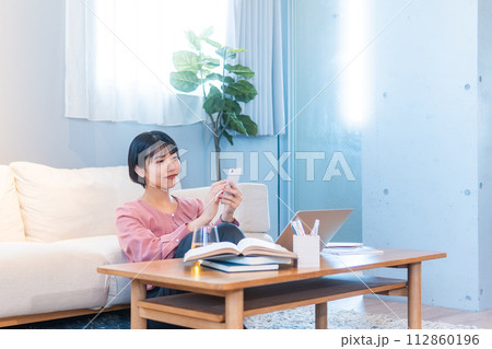 自宅で勉強/リモートワークをする女性 自宅で勉強/リモートワークをする女性 112860196