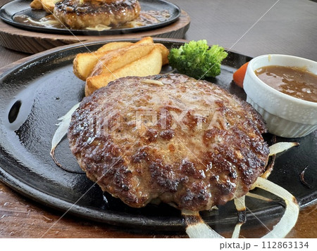 こんがりと焼き目のついたハンバーグステーキ こんがりと焼き目のついたハンバーグステーキ 112863134