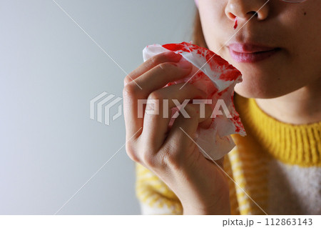 鼻血をティッシュ拭う女性 112863143