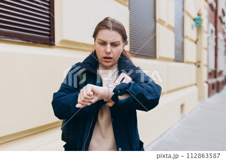 Frustrated and angry young woman, who waiting for a friend who late for an appointment. Urban lifestyle concept. Why are you late concept. I am waiting here for hours. 112863587