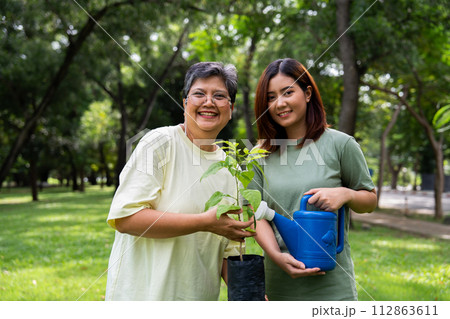 Portrait, Asian family mom and daughter plant sapling tree outdoors in nature park, Concept of happy retirement With care from a caregiver and Savings and senior health insurance, Happy family 112863611