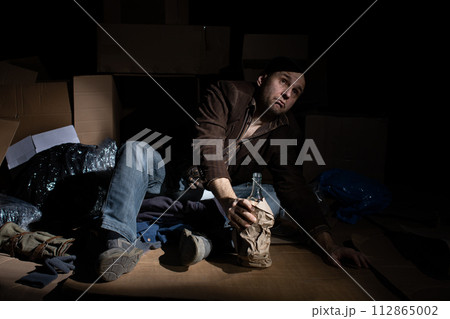 A middle-aged homeless man puts on woolen gloves. 112865002