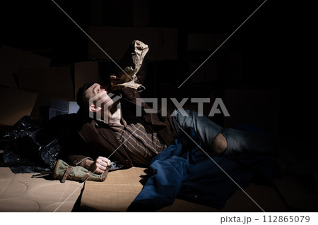 A middle-aged homeless man became alcoholic because of his situation. 112865079