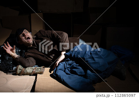 A middle-aged homeless man defends himself against danger. A middle-aged homeless man defends himself against danger. 112865097