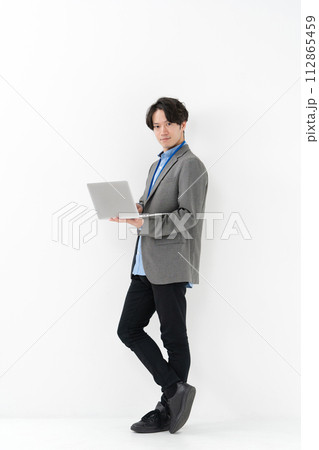 ノートパソコン持って立ち姿のビジネスマン 112865459