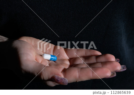 A tablet that treats ailments of a serious infectious disease given on a woman's hand. A tablet that treats ailments of a serious infectious disease given on a woman's hand. 112865639