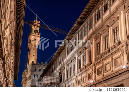 The famous Uffizi and the tower of the Palazzo Vecchio of Florence illuminated at night 112865961