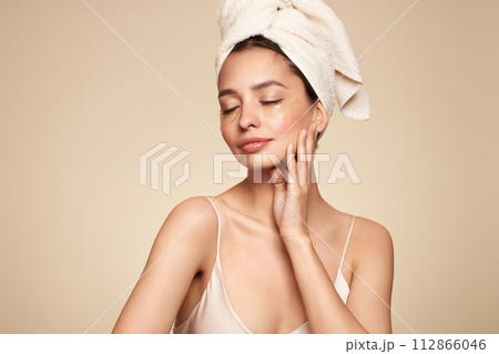 Young woman with cosmetic patches on her eyes Young woman with cosmetic patches on her eyes 112866046