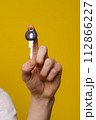 Close-up image of a man hand holding home key with isolated yellow background and copy space. Perfect for conveying concepts of homeownership, real estate, property, and security. High quality photo 112866227