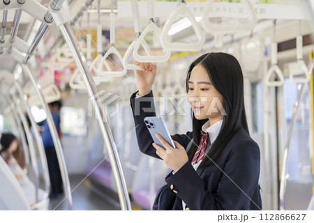 スマートフォンの画面を見る女子高校生　電車通学　イメージ 112866627