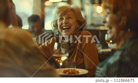 Joyful Senior Woman Laughing with Friends at a Cozy Restaurant. Candid Capture of Happiness and Togetherness in a Casual Setting. Perfect for Lifestyle and Social Themes. AI 112866675