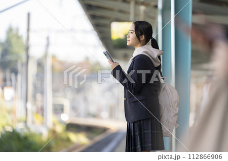 ホームで電車のを待つ女子学生　撮影協力「京王電鉄株式会社」 112866906