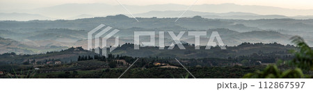 Typical Tuscan landscape with hills and cypresses in the very early morning near Montaione Typical Tuscan landscape with hills and cypresses in the very early morning near Montaione 112867597