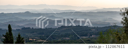 Typical Tuscan landscape with hills and cypresses in the very early morning near Montaione Typical Tuscan landscape with hills and cypresses in the very early morning near Montaione 112867611