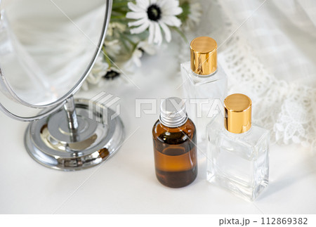 丸いミラーと白い花とガラス製容器の化粧品 112869382