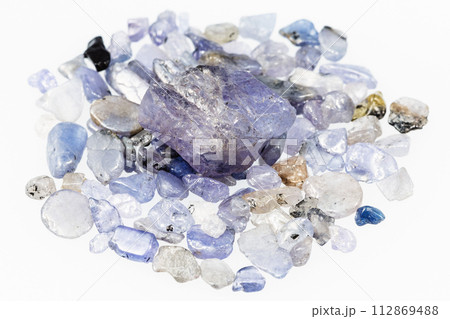 unpolished tanzanite crystal on gemstones on white 112869488