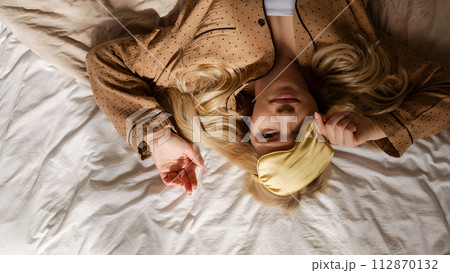 Overhead view of woman lying on bed Overhead view of woman lying on bed 112870132