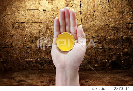 Gold coin in hand with gold leaf background Gold coin in hand with gold leaf background 112870134