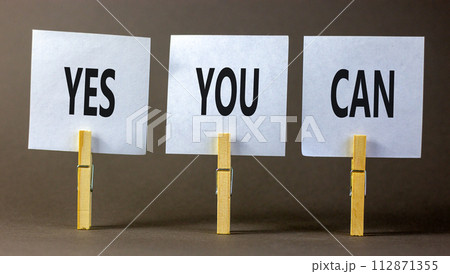 Motivational and Yes you can symbol. Concept words Yes you can on beautiful white paper on clothespin. Beautiful grey table grey background. Business motivational and Yes you can concept. Copy space. 112871355