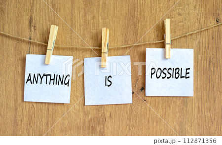 Anything is possible symbol. Concept words Anything is possible on beautiful white paper on clothespin. Beautiful wooden table wooden background. Business anything is possible concept. Copy space. 112871356