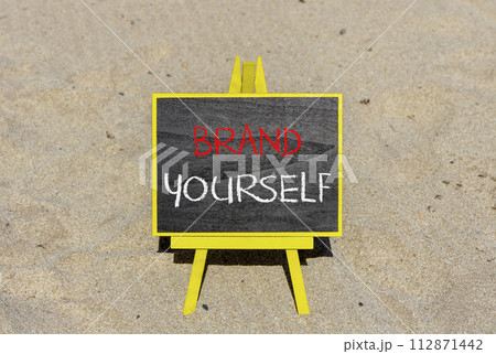 Brand yourself symbol. Concept words Brand yourself on beautiful black blackboard. Beautiful sand beach background. Business brand yourself concept. Copy space. Brand yourself symbol. Concept words Brand yourself on beautiful black blackboard. Beautiful sand beach background. Business brand yourself concept. Copy space. 112871442