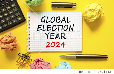 Global election year 2024 symbol. Concept words Global election year 2024 on beautiful white note. Beautiful yellow background. Calculator. Business Global election year 2024 concept. Copy space 112871448