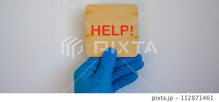 COVID-19 Pandemic Coronavirus concept.The doctor holds in his hand a tablet saying help. Gloved hand. 112871461