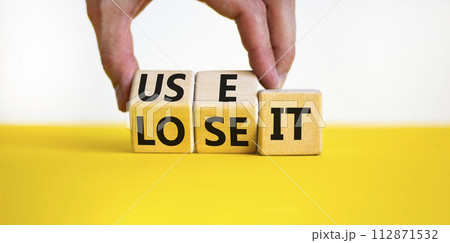 You use or lose it symbol. Concept word Use It or lose it on wooden cubes. Beautiful yellow table white background. Businessman hand. Business and you use or lose it concept. Copy space. You use or lose it symbol. Concept word Use It or lose it on wooden cubes. Beautiful yellow table white background. Businessman hand. Business and you use or lose it concept. Copy space. 112871532