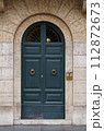 doors of Rome. Classic old wooden door in a public place on a city street or in an urban environment 112872673