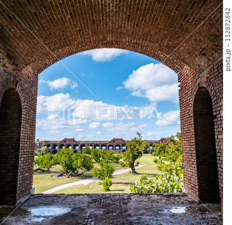 View through an open archway in Fort Jefferson on Dry Tortugas National Park with a the open courtyard a parade ground in the distance. View through an open archway in Fort Jefferson on Dry Tortugas National Park with a the open courtyard a parade ground in the distance. 112872842