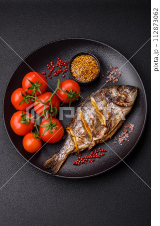 Delicious dorado baked on the grill with salt, spices and herbs Delicious dorado baked on the grill with salt, spices and herbs 112873062