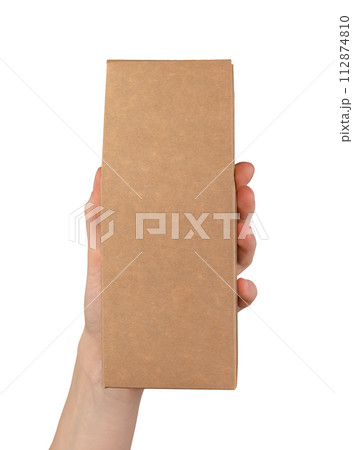 A hand holding a brown cardboard box A hand holding a brown cardboard box 112874810