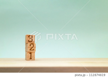 机の上に下から積み上げた3までのブロックが左端にあるふわりとした背景 112874819