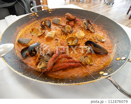 Rice with seafood in a large frying pan. Rice with seafood in a large frying pan. 112876079