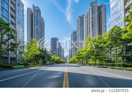 晴れた日の都会の大通りと緑豊かな街路樹 晴れた日の都会の大通りと緑豊かな街路樹 112887035