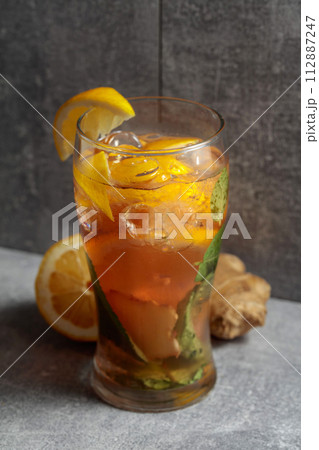 Iced tea with mint, ginger, and lemon on a grey background. 112887247