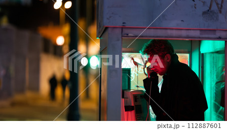 A man is talking on a phone at noir style in booth 112887601