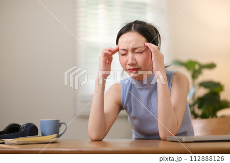 Asian college students are stressed out Sitting in front of a laptop studying online through a video calling program on a laptop at home. 112888126