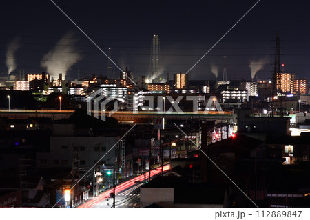 町の夜景に溶け込み白く立ち上る工場の煙 町の夜景に溶け込み白く立ち上る工場の煙 112889847