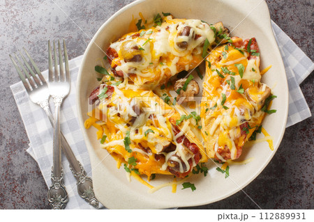 Alice Springs Chicken is a combination of chicken, bacon, cheese, mushrooms and honey mustard sauce closeup in the baking dish. Horizontal top view Alice Springs Chicken is a combination of chicken, bacon, cheese, mushrooms and honey mustard sauce closeup in the baking dish. Horizontal top view 112889931