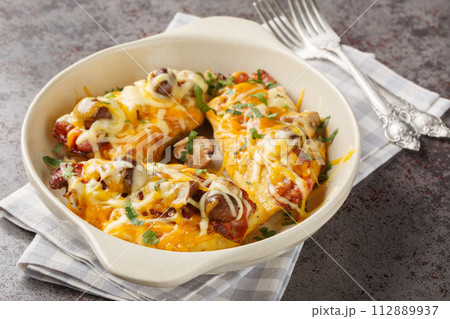Alice Springs Chicken is a combination of chicken, bacon, cheese, mushrooms and honey mustard sauce closeup in the baking dish. Horizontal Alice Springs Chicken is a combination of chicken, bacon, cheese, mushrooms and honey mustard sauce closeup in the baking dish. Horizontal 112889937